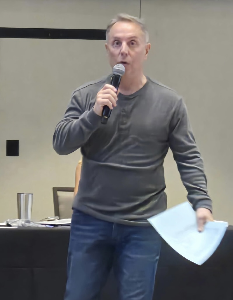 Joey Zoccali speaking on stage with microphone — authority shot
